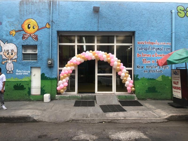 Fachada de Tadeopolis en la Colonia Obrera con mural infantil y arco de globos en la entrada