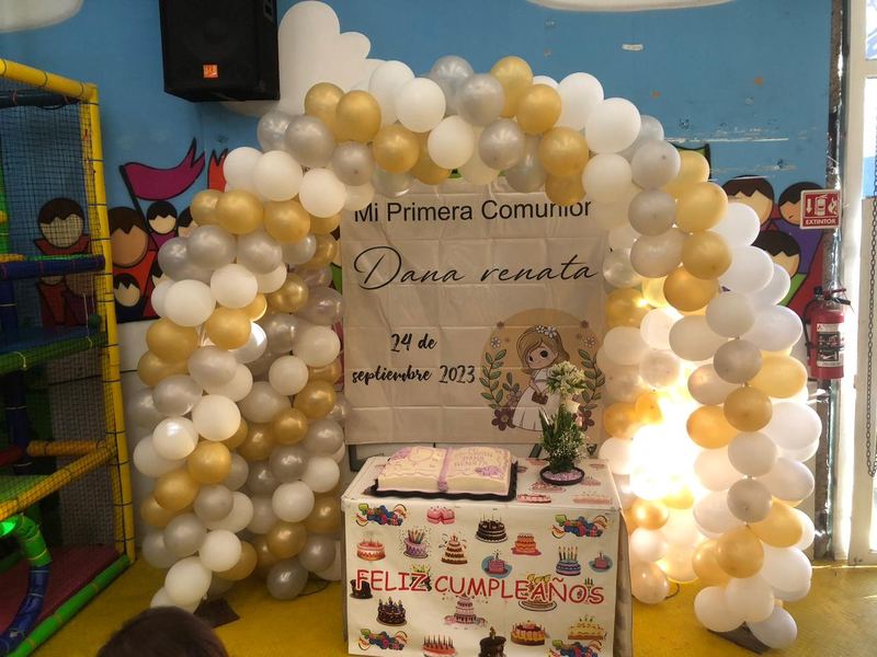 Mesa decorada para primera comunión con arco de globos blanco y dorado en Tadeopolis